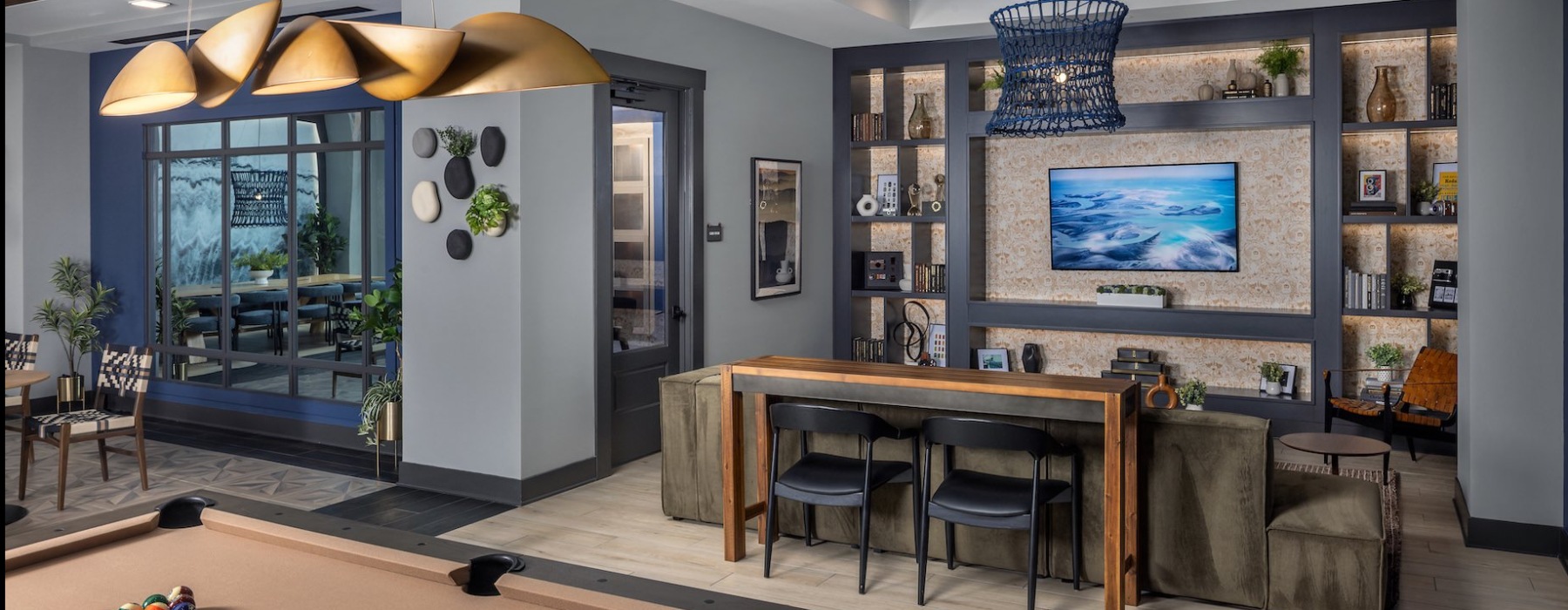 a lounge with a tv, couch, and a pool table