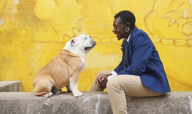 Broadstone West End is a pet-friendly community! a person and a dog sitting on a stone ledge