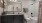 bathroom with a large mirror and grey cabinets