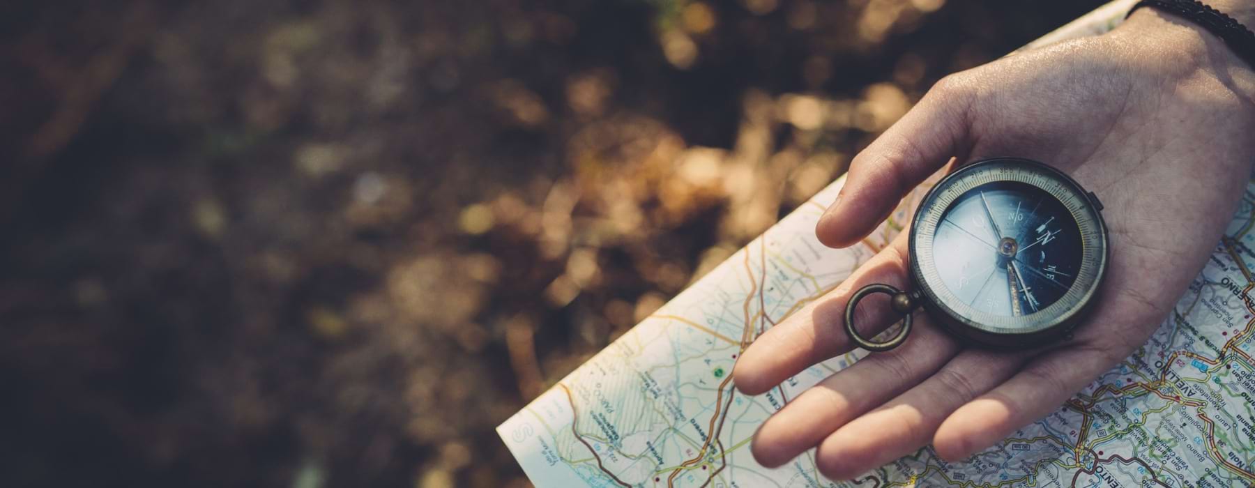 a hand holding a compass