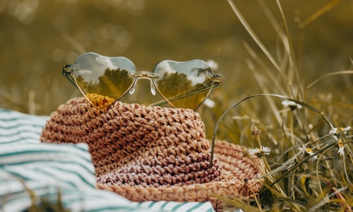 hat and sunglasses resting on the grass