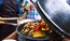 close-up of people cooking with a egg grill
